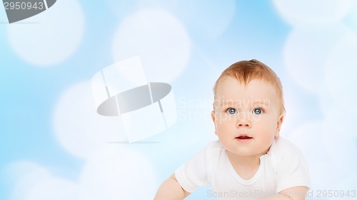 Image of smiling baby lying on floor and looking up