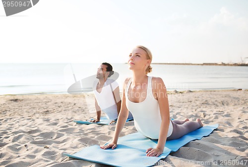 Image of couple making yoga exercises outdoors