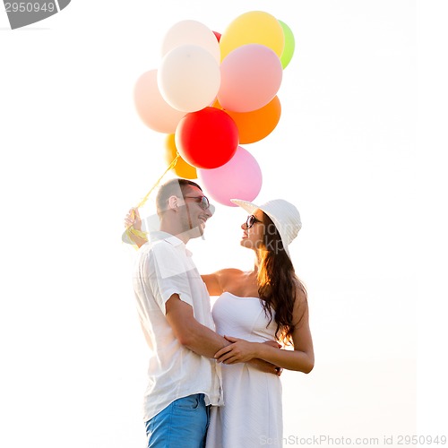 Image of smiling couple with air balloons outdoors