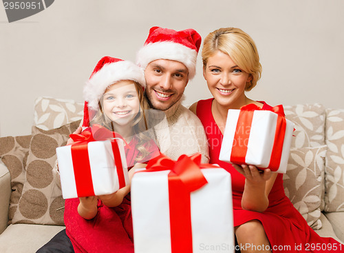 Image of smiling family giving many gift boxes