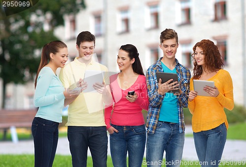 Image of group of teenagers with smartphones and tablet pc