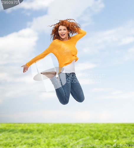 Image of smiling young woman jumping in air