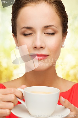 Image of smiling woman in red dress with cup of coffee