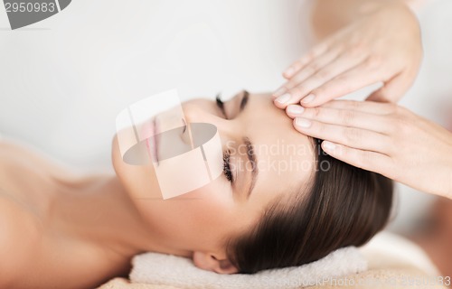 Image of beautiful woman in spa salon having facial