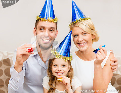 Image of smiling family in blue hats blowing favor horns