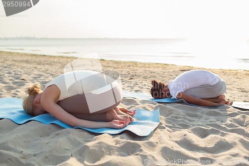 Image of couple making yoga exercises outdoors