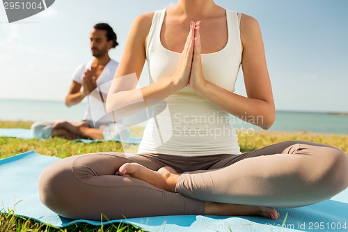 Image of close up of couple making yoga exercises outdoors