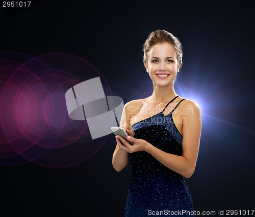 Image of smiling woman in evening dress with smartphone