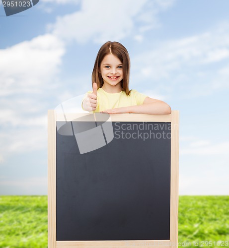 Image of happy little girl with blank blackboard