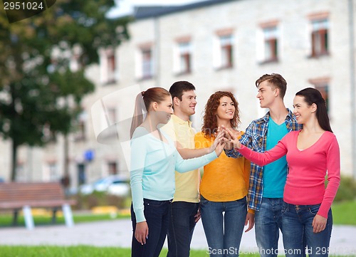 Image of group of smiling teenagers over campus background