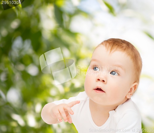 Image of curious baby lying on floor and looking side