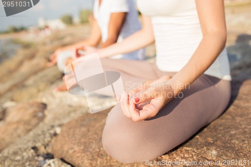 Image of close up of couple making yoga exercises outdoors