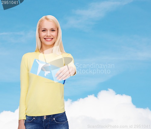 Image of smiling young woman with airplane ticket