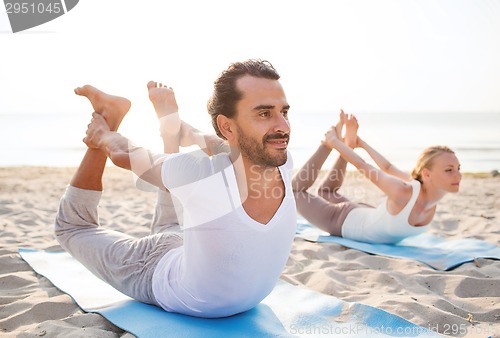 Image of couple making yoga exercises outdoors