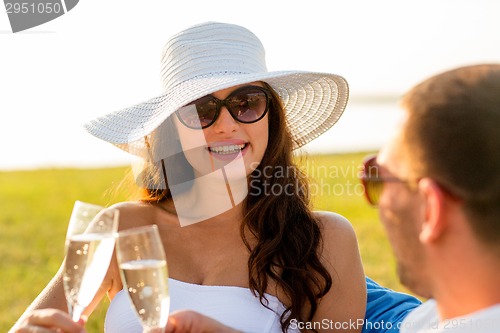 Image of smiling couple drinking champagne on picnic
