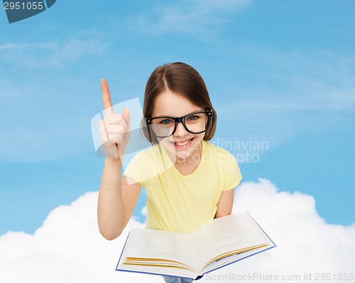 Image of smiling little girl in eyeglasses with book