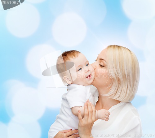 Image of happy mother kissing smiling baby