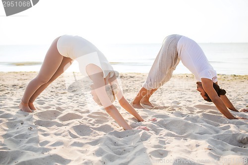 Image of couple making yoga exercises outdoors