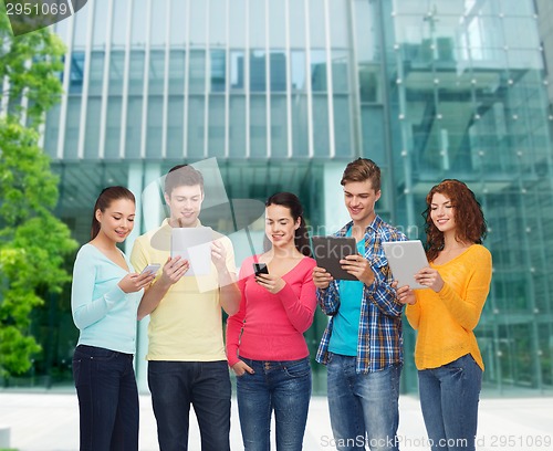 Image of group of teenagers with smartphones and tablet pc