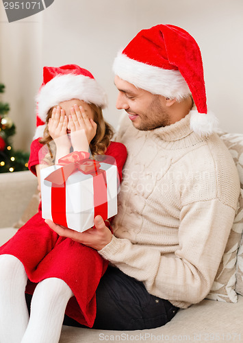 Image of smiling daughter waiting for a present from father