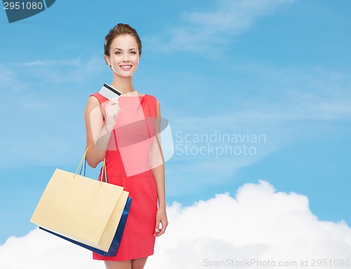 Image of smiling woman with shopping bags and plastic card