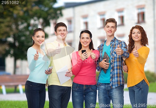 Image of group of teenagers with smartphones and tablet pc