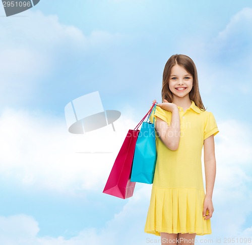 Image of smiling little girl in dress with shopping bags