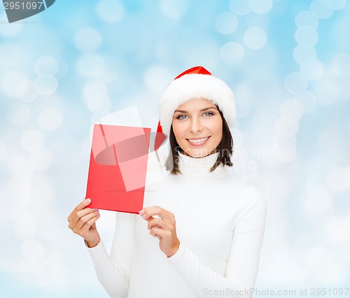 Image of smiling woman in santa hat with greeting card