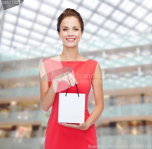 Image of smiling elegant woman in dress with shopping bag