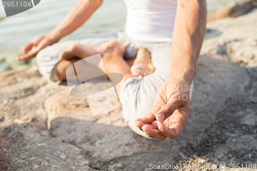 Image of close up of man making yoga exercises outdoors