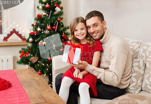 Image of smiling father and daughter holding gift box