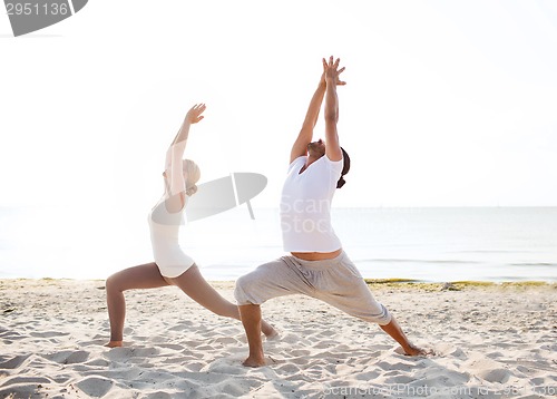 Image of couple making yoga exercises outdoors