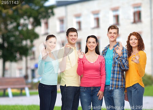 Image of group of smiling teenagers over campus background