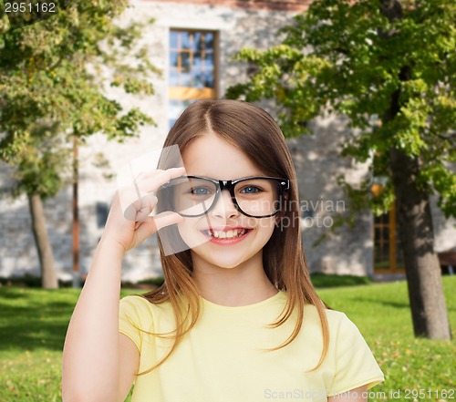 Image of smiling cute little girl in black eyeglasses