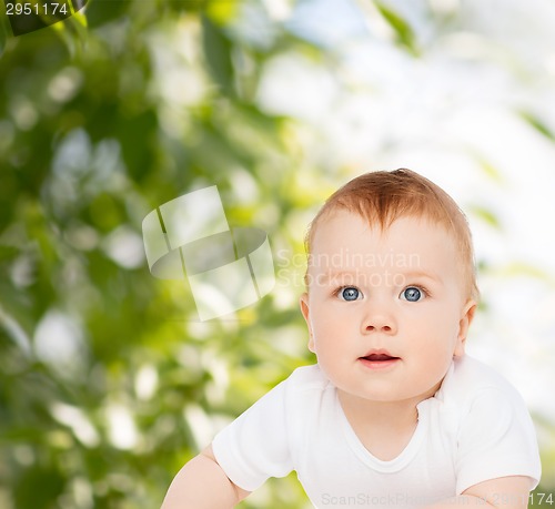 Image of smiling baby lying on floor and looking up