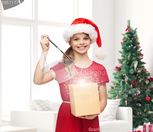 Image of smiling girl in santa helper hat with gift box