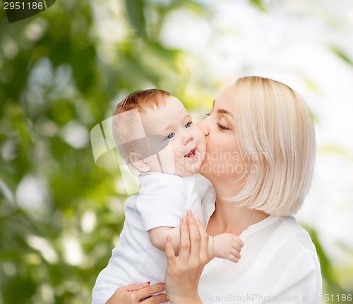 Image of happy mother kissing smiling baby