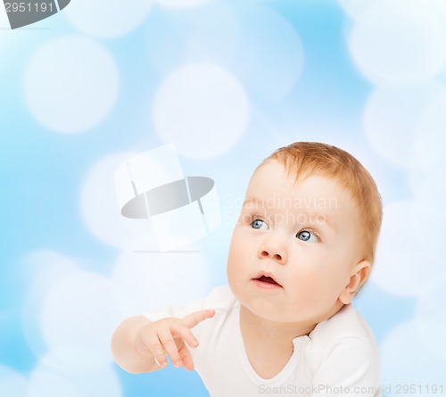 Image of curious baby lying on floor and looking side