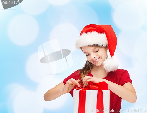 Image of smiling girl in santa helper hat with gift box