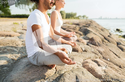 Image of close up of couple making yoga exercises outdoors