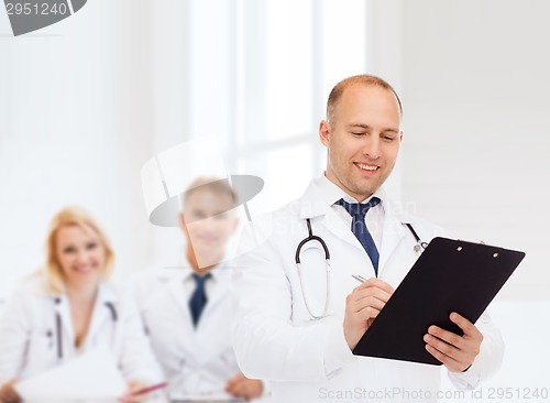 Image of smiling male doctor with clipboard and stethoscope