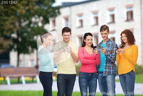 Image of group of smiling teenagers with smartphones