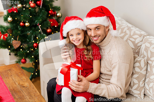 Image of smiling father and daughter holding gift box