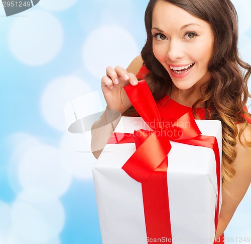 Image of smiling woman in red dress with gift box