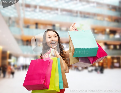 Image of smiling woman with colorful shopping bags