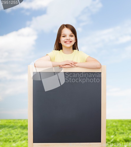Image of happy little girl with blank blackboard