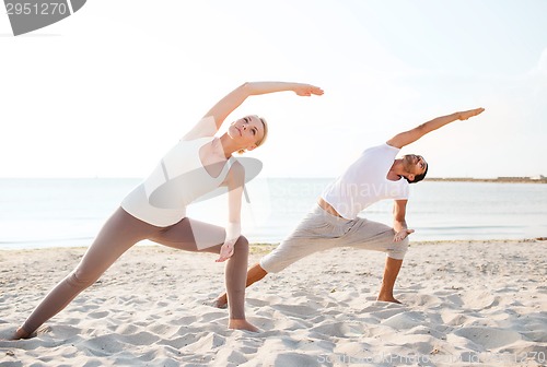 Image of couple making yoga exercises outdoors