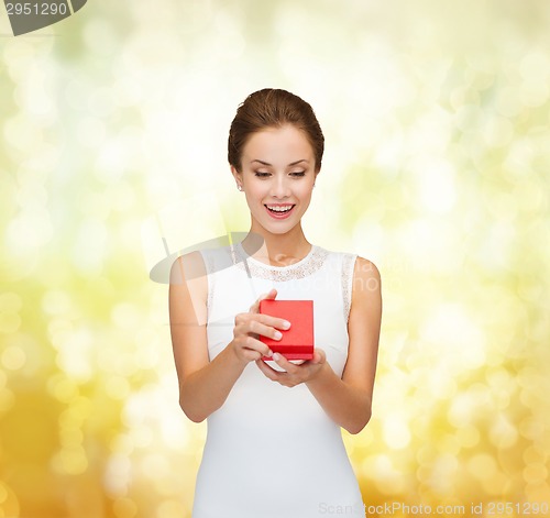 Image of smiling woman holding red gift box