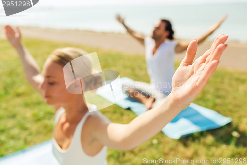 Image of close up of couple making yoga exercises outdoors