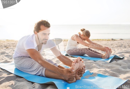 Image of couple making yoga exercises outdoors
